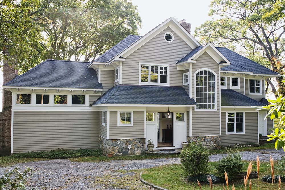 Exterior of grey two-storey home with front door open