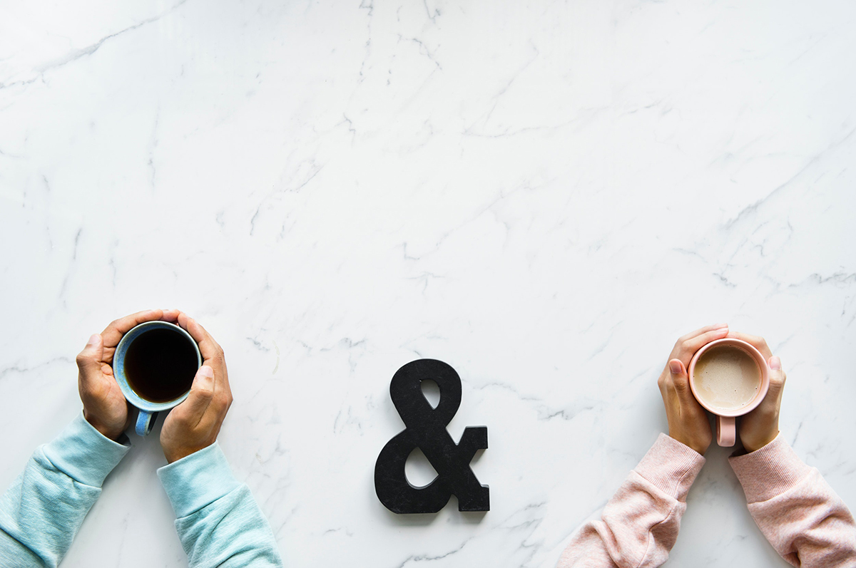 Two people with their hands with coffee on counter deciding on mortgage