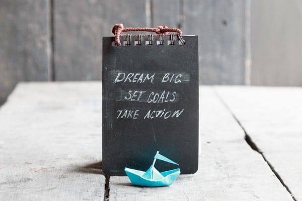 Blackboard that says dream big set goals take action