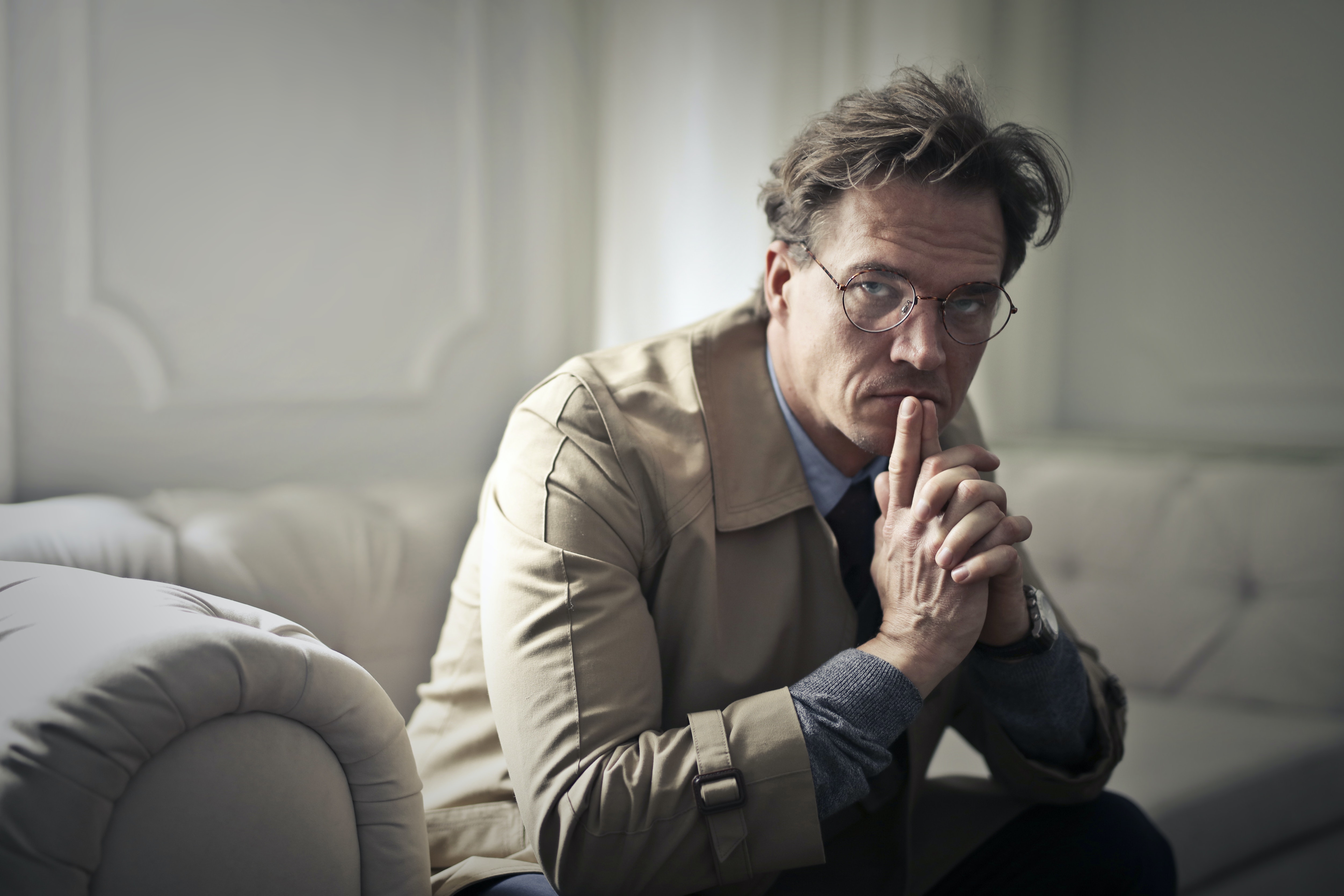 Man sitting on couch worried after being laid-off