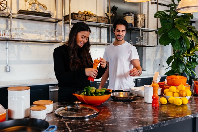 young couple preparing dinner in the house they just bought