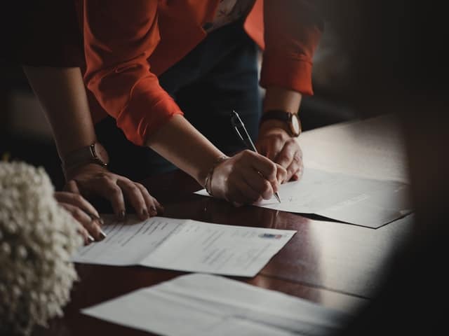 a woman signing as a guarantor for her daughter on her mortgage
