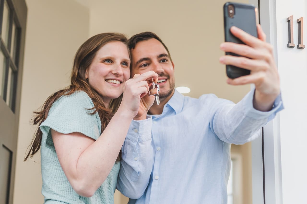 a happy couple taking a selfie with keys after buying a home with a mortgage pre-approval