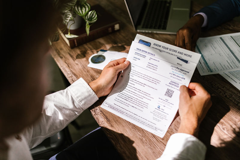 Person looking at his credit report document in his hands